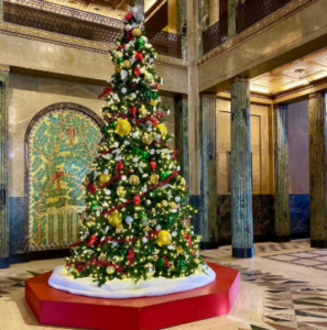Large decorated Christmas tree in an ornate building lobby.