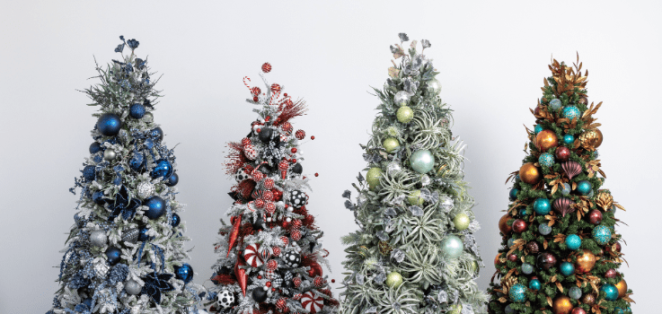 Four decorated Christmas trees in different color themes under an office holiday decor heading.