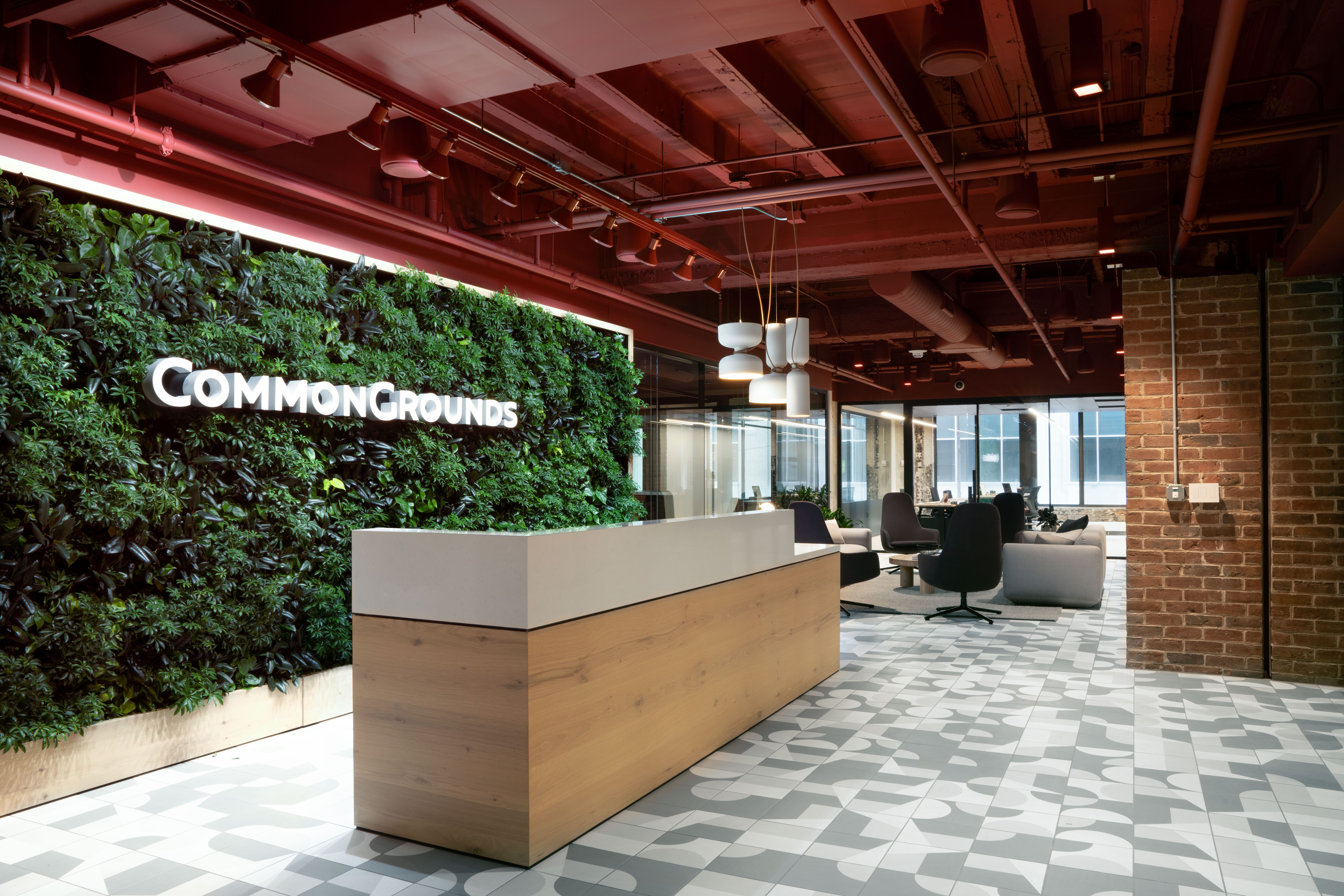 Modern office reception area featuring a large green living wall with company signage.