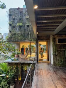 Eco-brutalist building interior with concrete architecture and lush greenery.