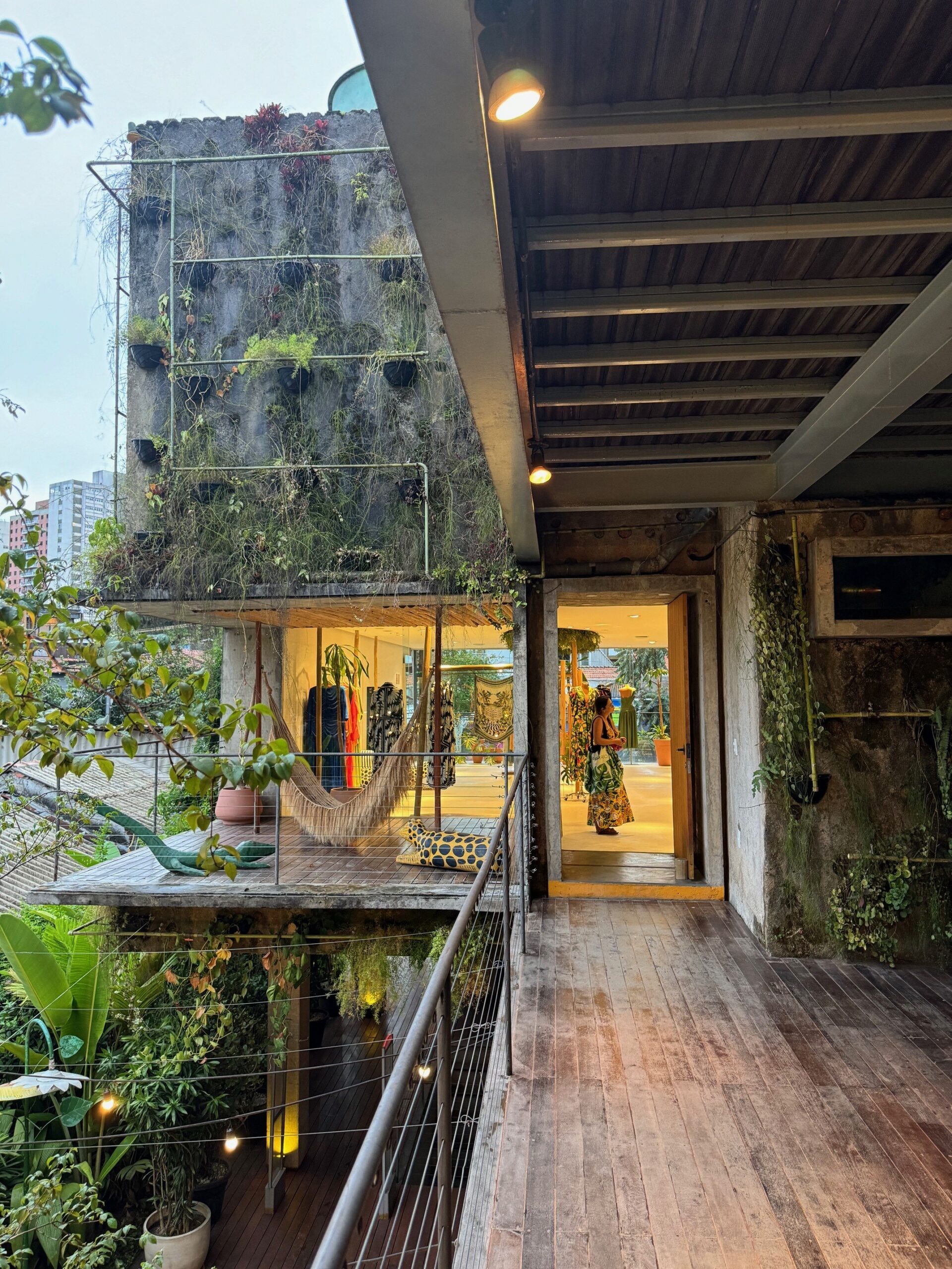 Eco-brutalist building interior with concrete architecture and lush greenery.